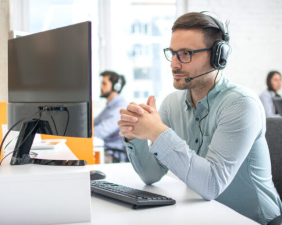 Customer service support operator man with headphones and microphone listening to his client in call center Customer service support operator man with headphones and microphone listening to his client in call center